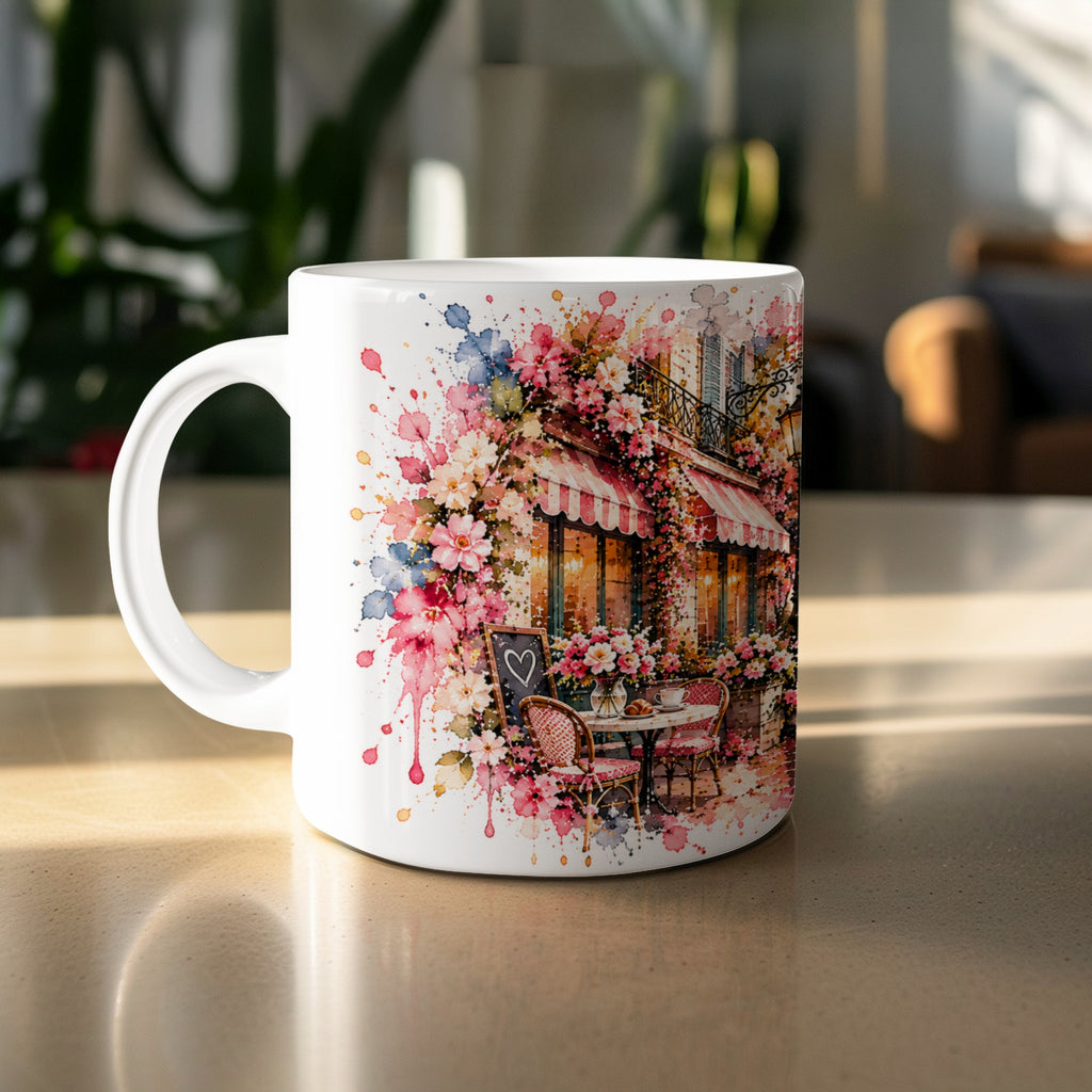 White mug with watercolor art of a Parisian cafe with flowers and outdoor seating.